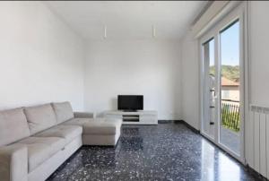 Sala de estar blanca con sofá y TV en Casa vacanze il Melograno en La Spezia