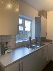 a kitchen with a sink and a window at House Next to the Station in Watford