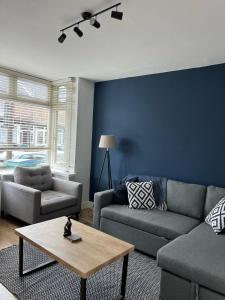 a living room with a couch and a table at House Next to the Station in Watford