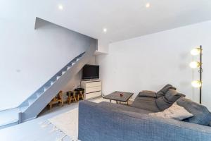 ein Wohnzimmer mit einem blauen Sofa und einer Treppe in der Unterkunft Loft, proximité centre et gare in Lille