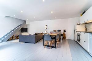 eine Küche und ein Wohnzimmer mit einem Tisch und einem Sofa in der Unterkunft Loft, proximité centre et gare in Lille