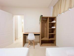 a bedroom with a desk and a white chair at Home By the Sea - HBS in Durrës