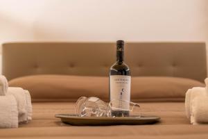 uma garrafa de vinho num prato com copos numa cama em [Trajetta - Suite] ¤ Through History&Music ¤ em Bitonto