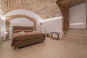 um quarto com uma cama e uma parede de pedra em [Trajetta - Suite] ¤ Through History&Music ¤ em Bitonto
