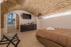 um quarto com uma cama grande e uma parede de pedra em [Trajetta - Suite] ¤ Through History&Music ¤ em Bitonto