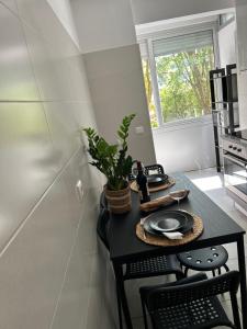 une cuisine avec une table et une plante. dans l'établissement Apartamento acolhedor em Queluz, à Queluz