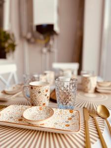 a table with plates and cups and utensils on it at Serbian House in Timişoara +15 photos