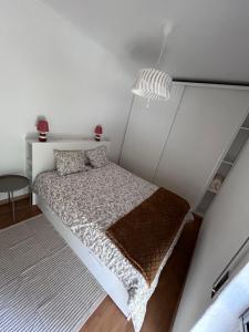 ein kleines Schlafzimmer mit einem Bett und einem Teppich in der Unterkunft Apartamento acolhedor em Queluz in Queluz