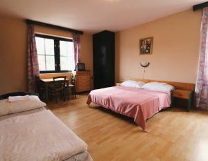 a hotel room with two beds and a table and a desk at Müller's 3 in Siófok