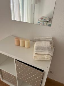 a white shelf with towels on it in front of a mirror at Apartamento acolhedor em Queluz in Queluz +13 photos