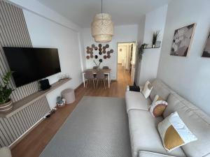 a living room with a couch and a flat screen tv at Apartamento acolhedor em Queluz in Queluz