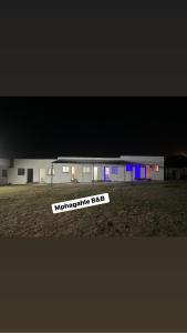 un edificio con un cartel delante de él por la noche en Mphagahle B&B, en Mthenti