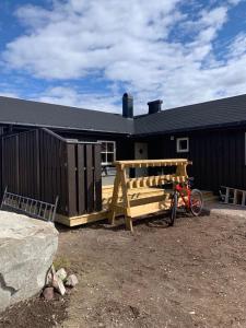 a wooden bench in front of a building at Beautiful cabin close to activities in Trysil, Trysilfjellet, with Sauna, 4 Bedrooms, 2 bathrooms and Wifi in Trysil