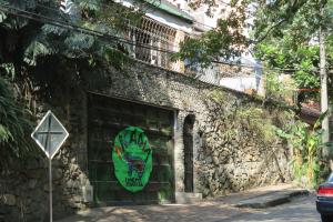 un edificio de piedra con una señal verde. en Arcadia Hostel Medellin, en Medellín