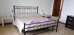 een slaapkamer met een bed met 2 paarse handdoeken erop bij Arcobaleno in Pozzolengo