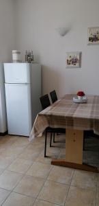 een keuken met een tafel en een witte koelkast bij Arcobaleno in Pozzolengo