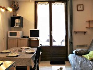 a living room with a table and a couch and a window at Appartement Risoul, 1 pièce, 4 personnes - FR-1-330-61 in Risoul