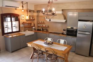 a kitchen with a wooden table and a refrigerator at OSTRIA BOUTIQUE HOME in Kalymnos