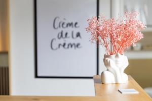eine weiße Vase mit rosa Blumen auf dem Tisch in der Unterkunft B&B Casa Fanny Riviera Del Conero in Loreto
