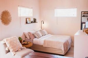 a small bedroom with a bed and a chair at Garden Oasis in Windhoek