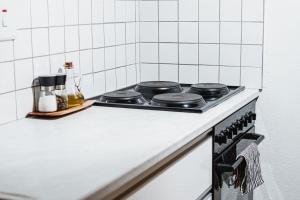 uma placa de fogão numa cozinha com azulejos brancos em Garden Oasis em Windhoek