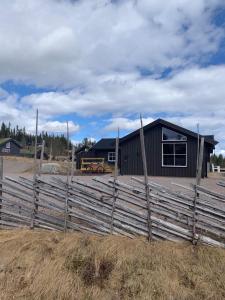 a wooden fence in front of a building at Beautiful cabin close to activities in Trysil, Trysilfjellet, with Sauna, 4 Bedrooms, 2 bathrooms and Wifi in Trysil