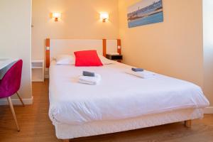 ein Schlafzimmer mit einem weißen Bett mit zwei Handtüchern darauf in der Unterkunft Hôtel de la Mairie in Saint-Pol-de-Léon