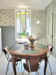 cocina con mesa y sillas en una habitación en Les Colibris - Standing et Montagnes - 3 étoiles, en Cluses