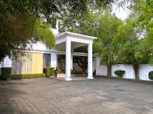 a white house with a pavilion in a driveway at Grand Detagamuwa in Kataragama