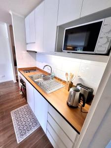 a small kitchen with a sink and a microwave at 201/ Precioso apartamento 1D+1B Centro + Jumbo 5 min in Puerto Montt