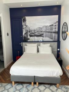 a bedroom with a large bed with a blue headboard at Chambre dans Hôtel Particulier 18e siècle Hyper Centre La Rochelle in La Rochelle