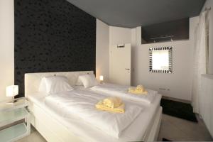 Un dormitorio con una cama blanca con toallas. en Mountain Rooms - Night only - Self Check in en Zell am See