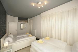 a white bedroom with two beds and a window at Mountain Rooms - Night only - Self Check in in Zell am See