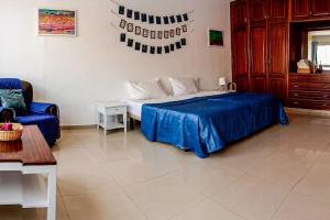 een slaapkamer met een bed, een bank en een tafel bij Mantenha ApartHotel in Praia