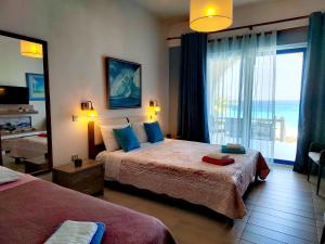 sypialnia z 2 łóżkami i widokiem na ocean w obiekcie villa vagelis w mieście Mourteri