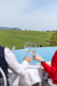 2 personnes assises à une table avec vue sur la piscine dans l'établissement B&B Casa Fanny Riviera Del Conero, à Loreto