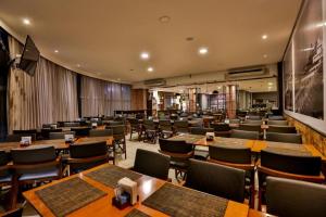 H1503 Suíte Luxo Flat Hotel Aeroporto Congonhas في ساو باولو: مطعم فيه طاولات وكراسي في الغرفة