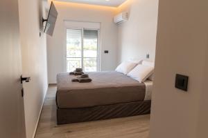 a bedroom with a bed and a window at oiKOS Hospitality in Kos