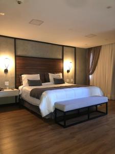 a large bedroom with a large bed with a wooden headboard at Cataratas Park Hotel e Eventos in Foz do Iguaçu