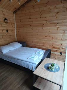 una habitación con una cama y una mesa con un plato. en Domek Modern Barn- 3 tylko 800m od Suntago RANCZO GOLD MANIA en Krzyżówka