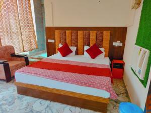 1 dormitorio con 1 cama con almohadas rojas en Hotel Vasudeva Palace Near Ram Janam Bhumi en Ayodhya