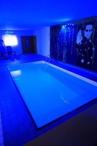 a large swimming pool in a room with blue lights at Casa FedericaPet con piscina interna privata e riscaldata in Pagliare