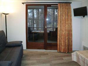 a living room with a sliding glass door with a balcony at Appartement Les Orres, 1 pièce, 4 personnes - FR-1-322-289 in Les Orres