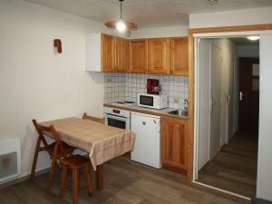 a small kitchen with a table and a microwave at Appartement Les Orres, 1 pièce, 4 personnes - FR-1-322-289 in Les Orres