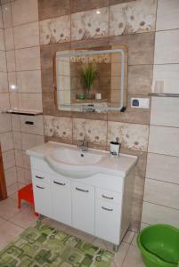La salle de bains est pourvue d'un lavabo et d'un miroir. dans l'établissement Noclegi nad Leśniówką, à Żarki