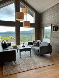 Sala de estar con 2 sofás y mesa en Nydelig hytte ved Voss Ski og Tursenter, en Giljane
