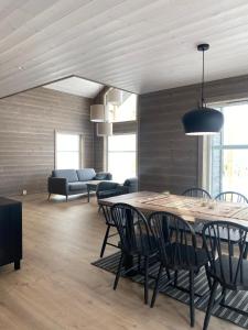 una sala da pranzo con tavolo, sedie e divano di Nydelig hytte ved Voss Ski og Tursenter a Giljane