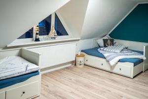 duas camas num quarto com duas janelas em Ferienhaus Wattbrise em Büsum