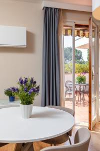 Una mesa blanca y sillas en una habitación con balcón. en Residence Poggio Golf Chianti Firenze en Impruneta