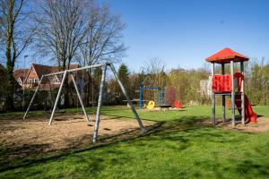 um parque com um baloiço e um parque infantil em Ferienhaus Wattbrise em Büsum
